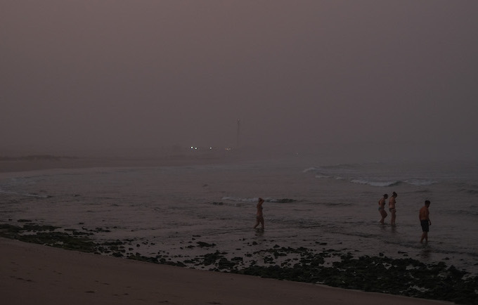 Teilnehmer baden bei Sonnenuntergang im Meer