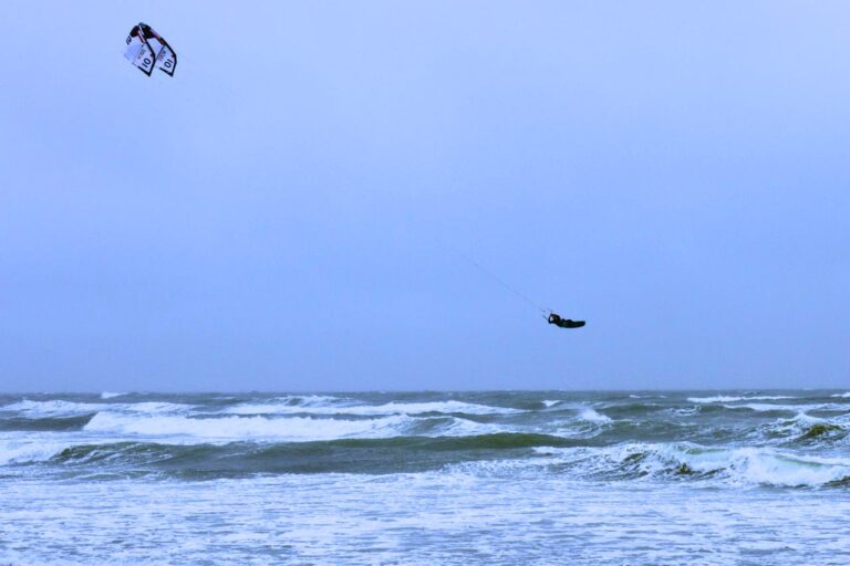 Boogieloop lernen - Kiter springt hoch in der Luft mit dem Kite vor sich im Windfenster