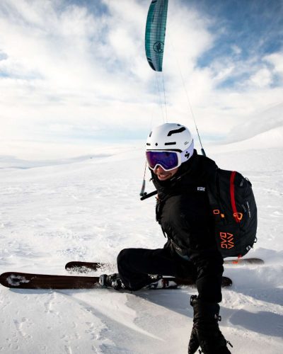 Olsen kitet mit Skiern und Foilkite in Norwegen und blickt in die Kamera